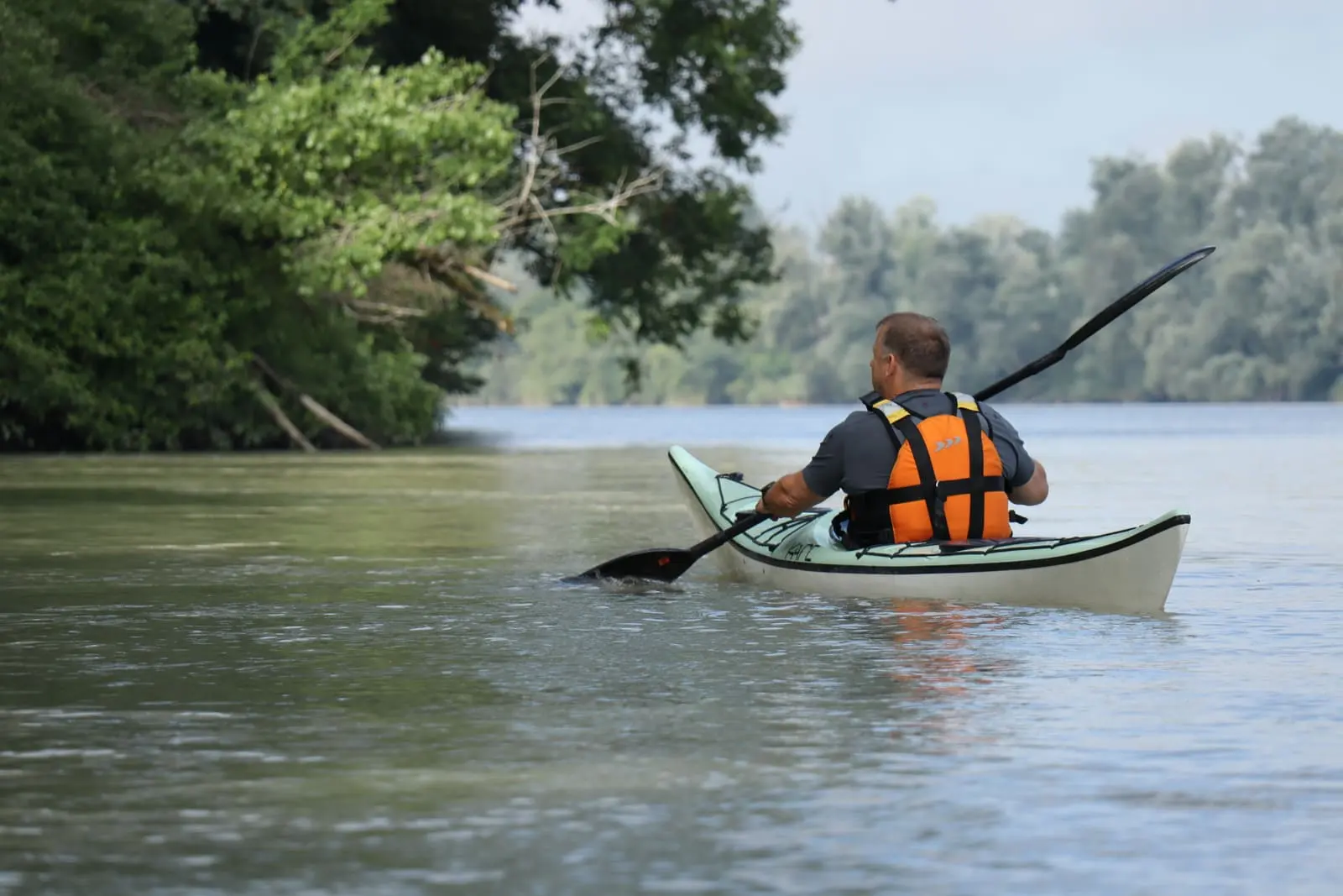Paddler in einem Boot auf dem ruhigen Wasser des Inn